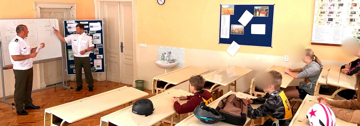 Vojenští policisté z táborského velitelství vysvětlují mladým cyklistům princip orientace v mapě